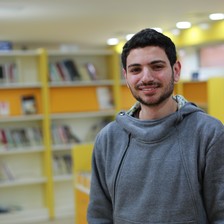 Smiling young man stands in library