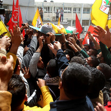 Photo shows hands reaching towards Murad Abu Ghazi as his body is carried during his funeral procession