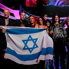 Group of people on Eurovision stage hold Israeli flag