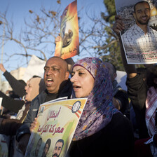 Young woman holds a poster in a crowd of protesters