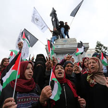 Crowd of women holding Palestinian flags and signs