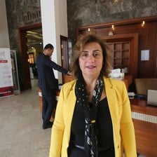 Mona Adnan Ghalayini stands in front of reception desk