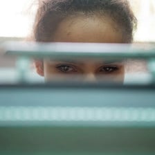 Sanabel, 14, is seen through a slit of her braille typewriter on which she is working during a class at the Peace Center for the Blind in occupied East Jerusalem.