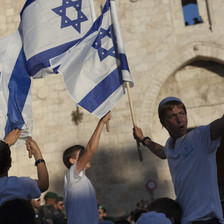 Youths wave Israeli flags in front of the Damascus Gate to Jerusalem's old city