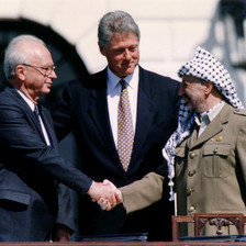 Photo shows Yitzhak Rabin and Yasser Arafat shaking hands while Bill Clinton extends his arms behind them