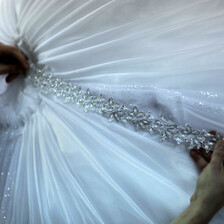 A designer puts the final touches to a wedding dress. 