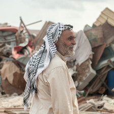 Omar Arif Bisharat stands in front of the rubble of his home in al-Hadidiya.