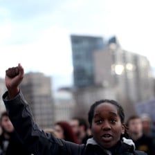 Black person raises fist in air during protest