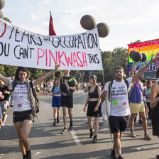 Marching young people carry a banner declaring "70 years of occupation. You can't pinkwash this"