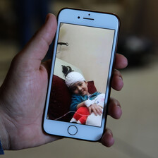 A picture on a mobile phone shows a bandaged girl smiling