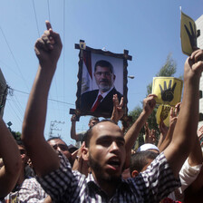 Large photo of Morsi carried above protesters