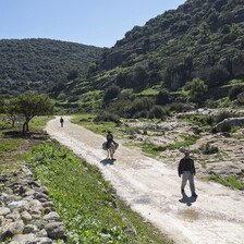 A man and child on a road between mountains