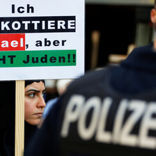 Woman holds placard as she stands beside police officer