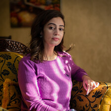 Woman sits on a cushioned chair 