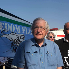 Two men stand in front of banner reading "Freedom Flotilla" 