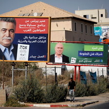 Two men are seen on two separate election posters in front of a house