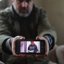 Man holds smart phone towards camera