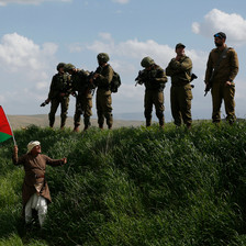 A man waves a Palestinian flag in front of a group of Israeli soldiers