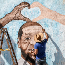 A man paints a mural on a wall in Gaza