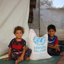 Two children sit on the ground 