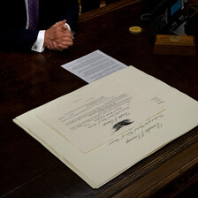 A document lies on a wooden desk