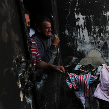Man weeps in badly damaged house 
