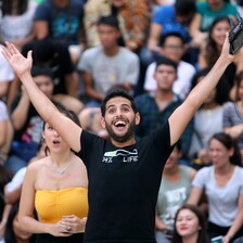 Man stands before crowd with arms wide open 