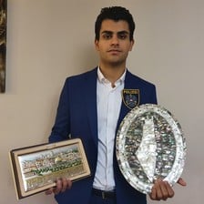 Man holds plaque in each hand 