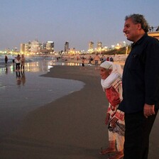 Woman and man stand on a beach 