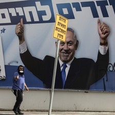 An election poster covered with graffiti carries Benjamin Netanyahu's triumphant image
