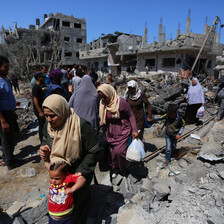 Women walk amid rubble 