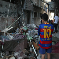 Child stands amid debris left after a bomb attack 