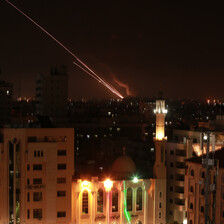 A streak of light from a rocket blazes through a dark sky