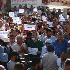 Demonstrators hold up signs in Arabic