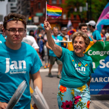 Woman waves rainbow flag as people march