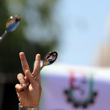 Hands hold up spoons and victory signs