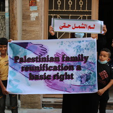 Two children hold a poster reading "Palestinian family reunification is a basic right"