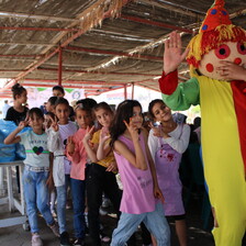 Children play behind a clown