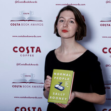 Woman holds a copy of a book 