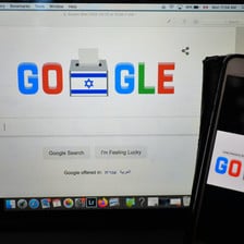 A computer and mobile phone screen, both showing the word Google