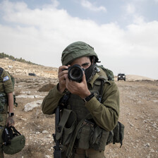 Man in uniform holds camera to his face