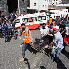 A group of men carry another man on a stretcher 