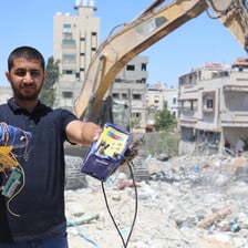 A man shows off what he has found in the rubble of a building