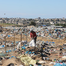 Boy holds plastic bag in a dump 