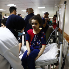 A young girl is treated on a hospital bed