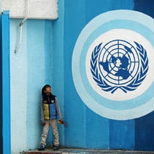 A boy looks up at the UN logo in Gaza City