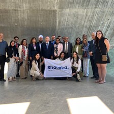 Group of people pose with a banner that says "Sharaka" 