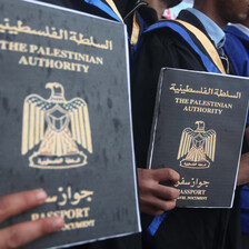 A group of men hold signs resembling passports with the words Palestinian Authority written on them