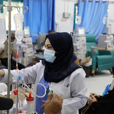 A doctor checks a screen in a hospital ward
