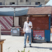 A man stands with a tray in front of a small wooden booth